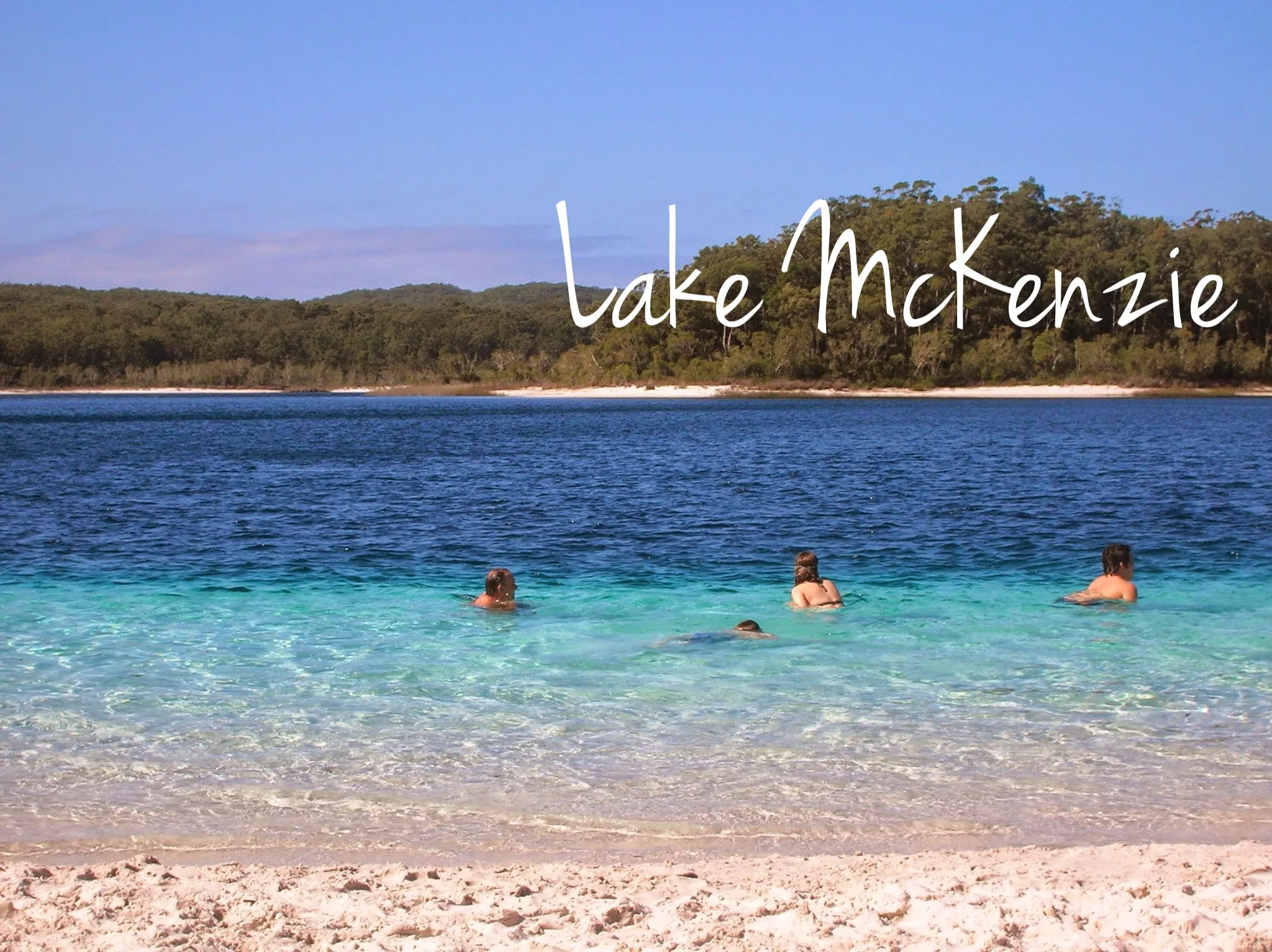 people swimming in a turquoise, picture-perfect lake 