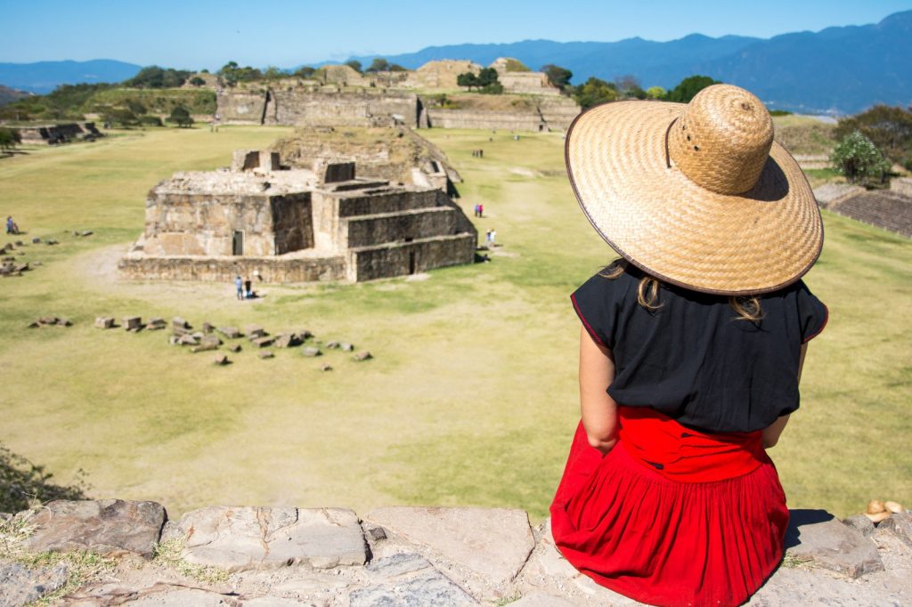 Image of woman sitting on a pyramid at the Monte Alban ruins, mexico