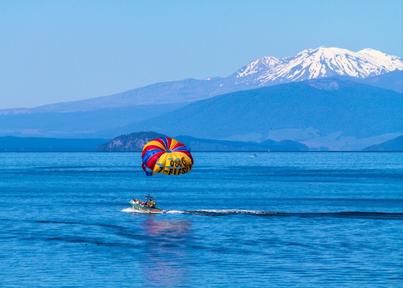 A boat in a lake, and a snow-capped mountain in the background