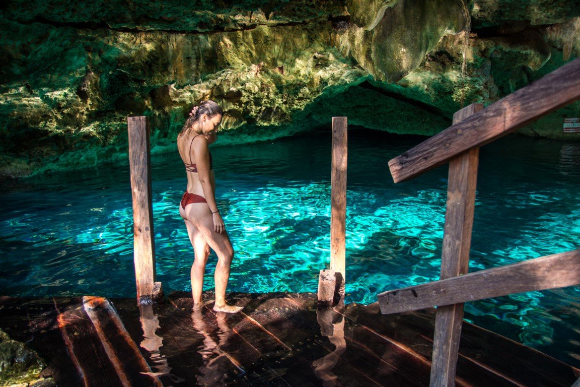Woman standing in front of Cenote Dos Ojos, Tulum, one of the most beautiful cenotes in Tulum.
