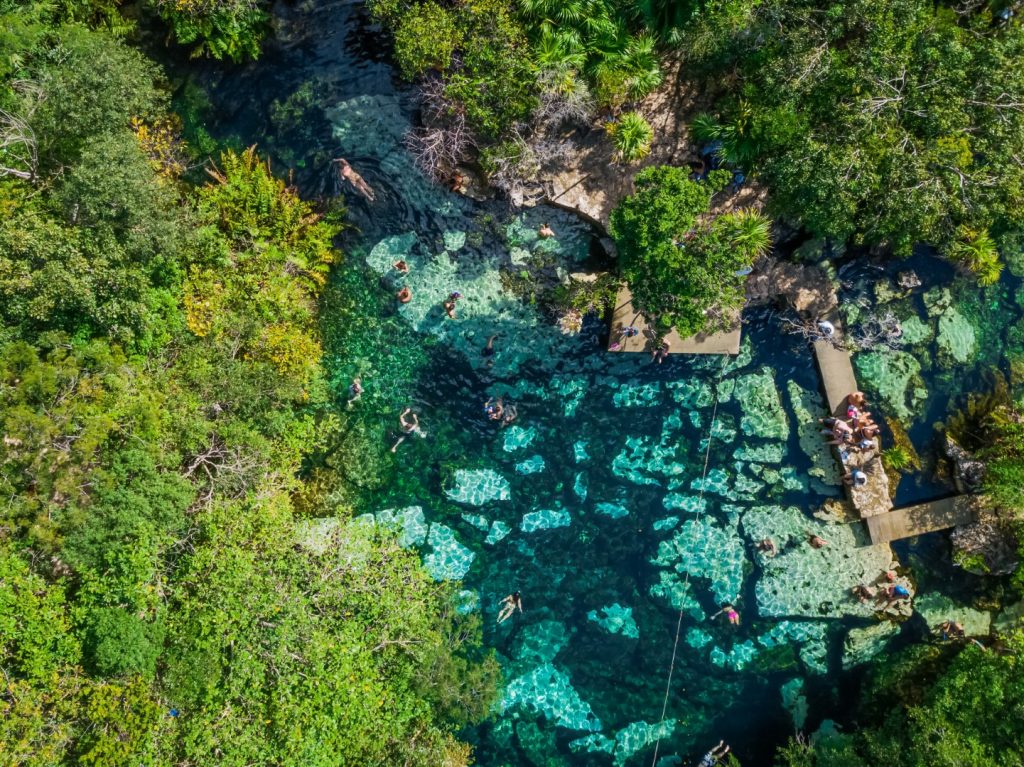 An overhead shot of Cenote Azul, surrounded by lush vegetation