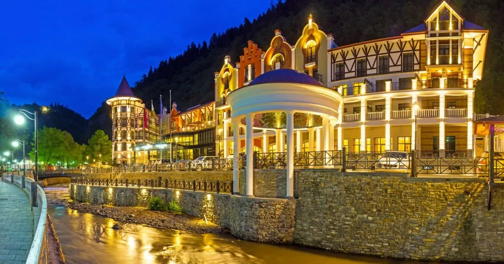 An elegant building by a river, liit up for the night