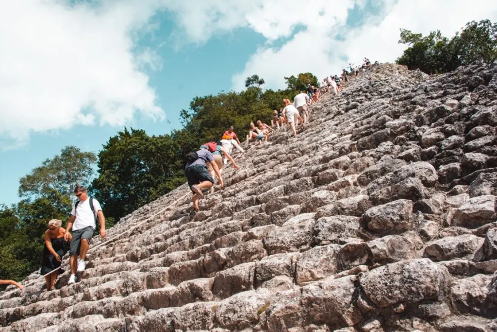 People climbing the  Nohoch Mul Pyramid in Cozumel, inserted in a post about Mayan ruins