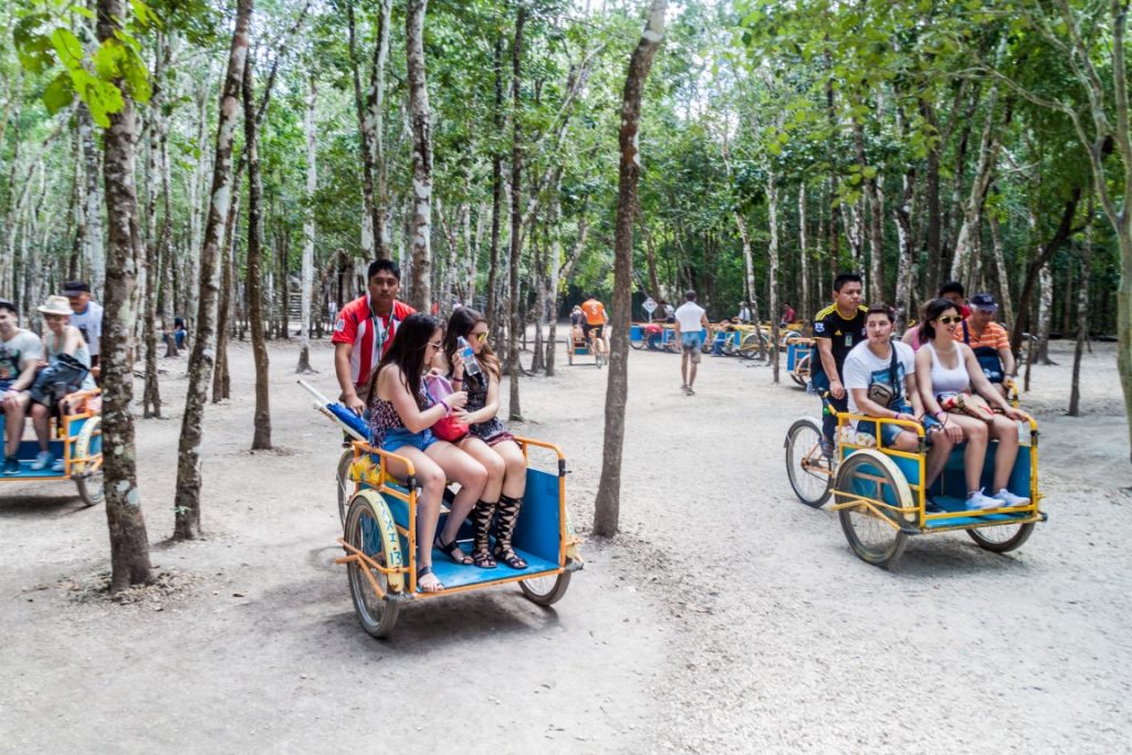 bici-taxis with two passengers sitting, and a man pedaling behind them