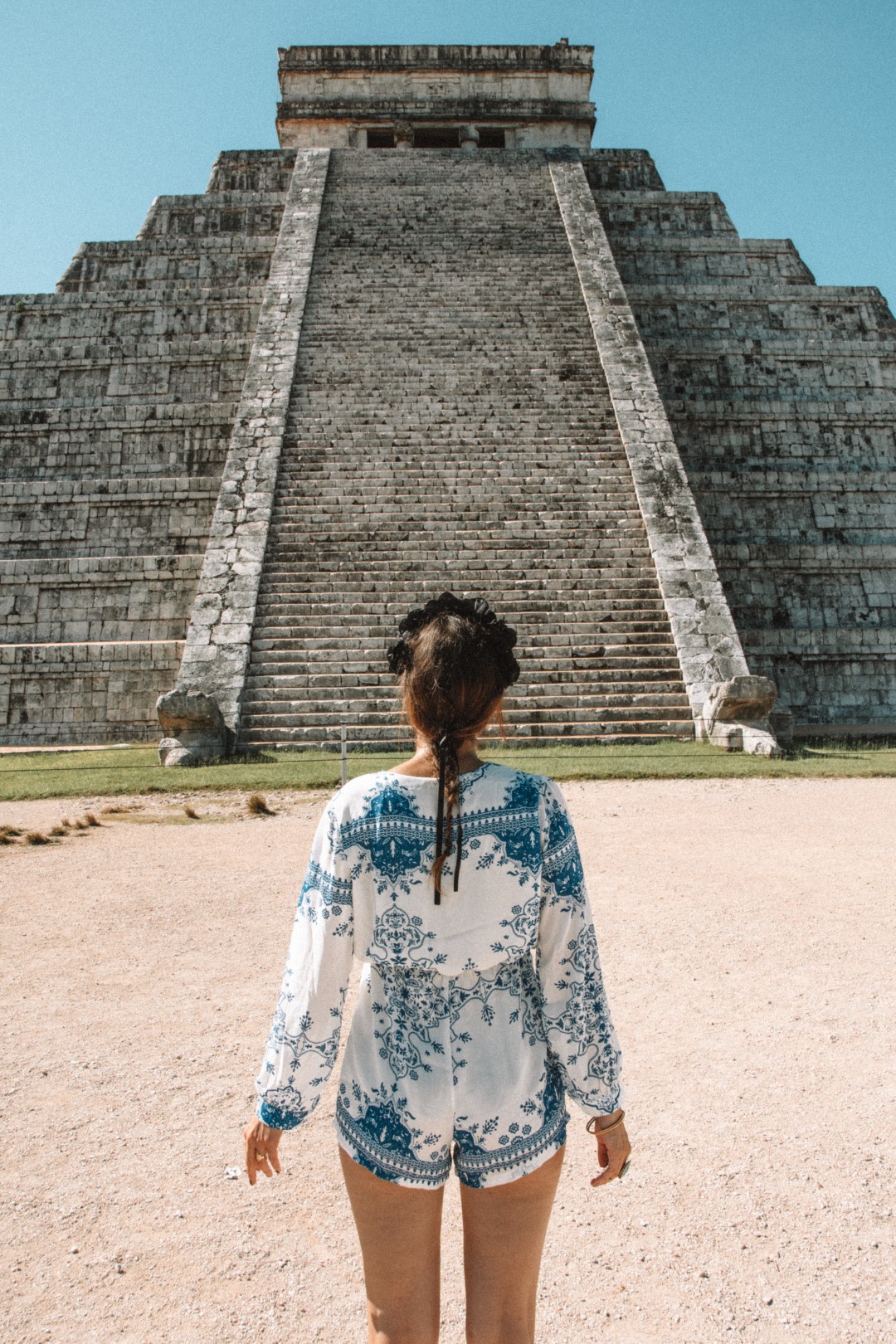 Woman standing in front of El Castillo Pyramid, inserted in a post about going from Playa del Carmen to Chichen Itza.