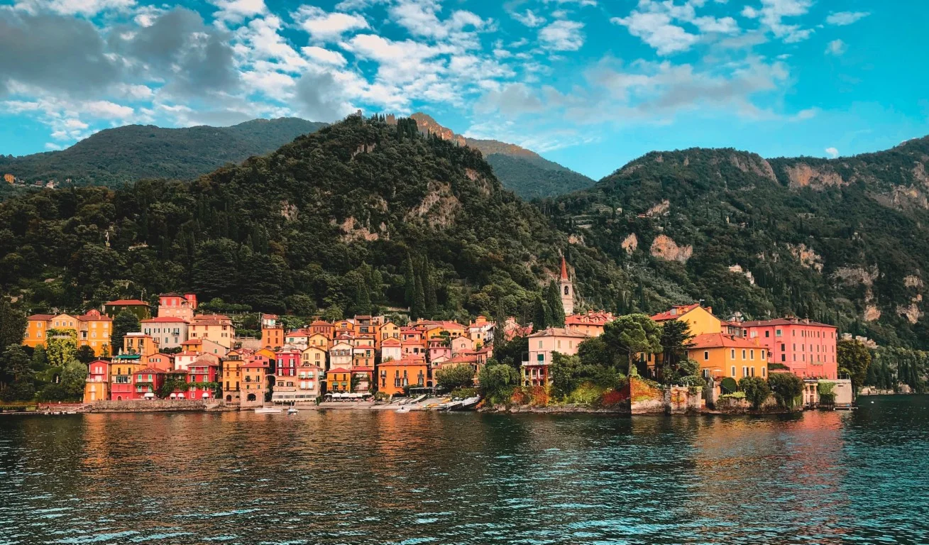 Lake Como, with colorful houses and tree-covered hills in the background
