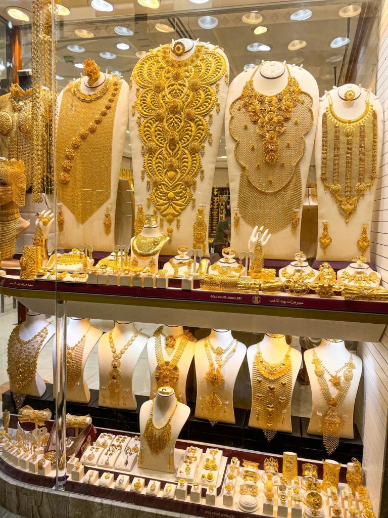 Image of a window display with gold necklaces, rings, and accessories of all sizes, in one of the most famous souks in Dubai: the Gold Souk