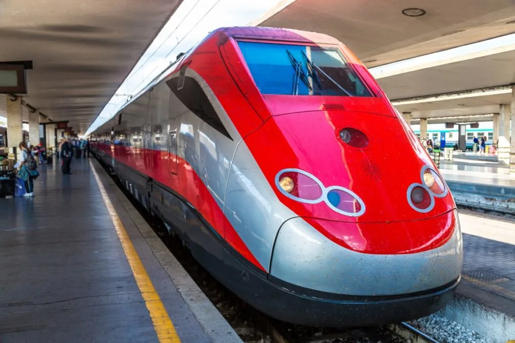 A red and grey train in a train station