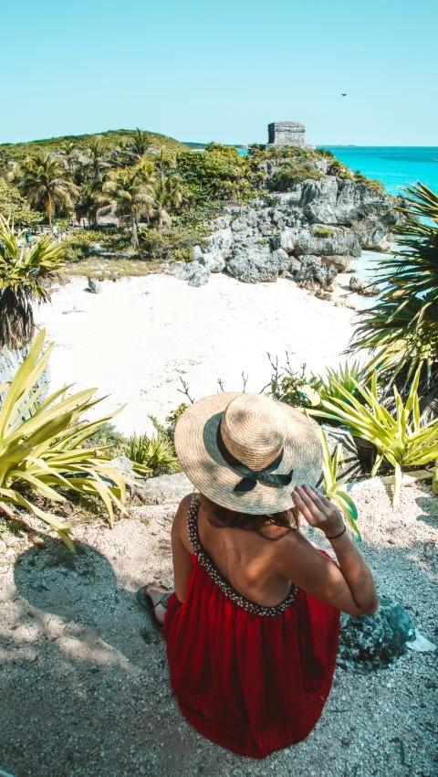 A woman overlooking the secret beach and Tulum Ruins, inserted in a post about Mayan ruins