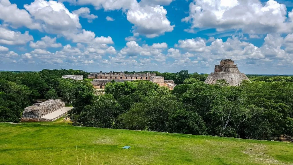 An image of the Mayan ruins of Uxmal, surrounded by thick vegetation