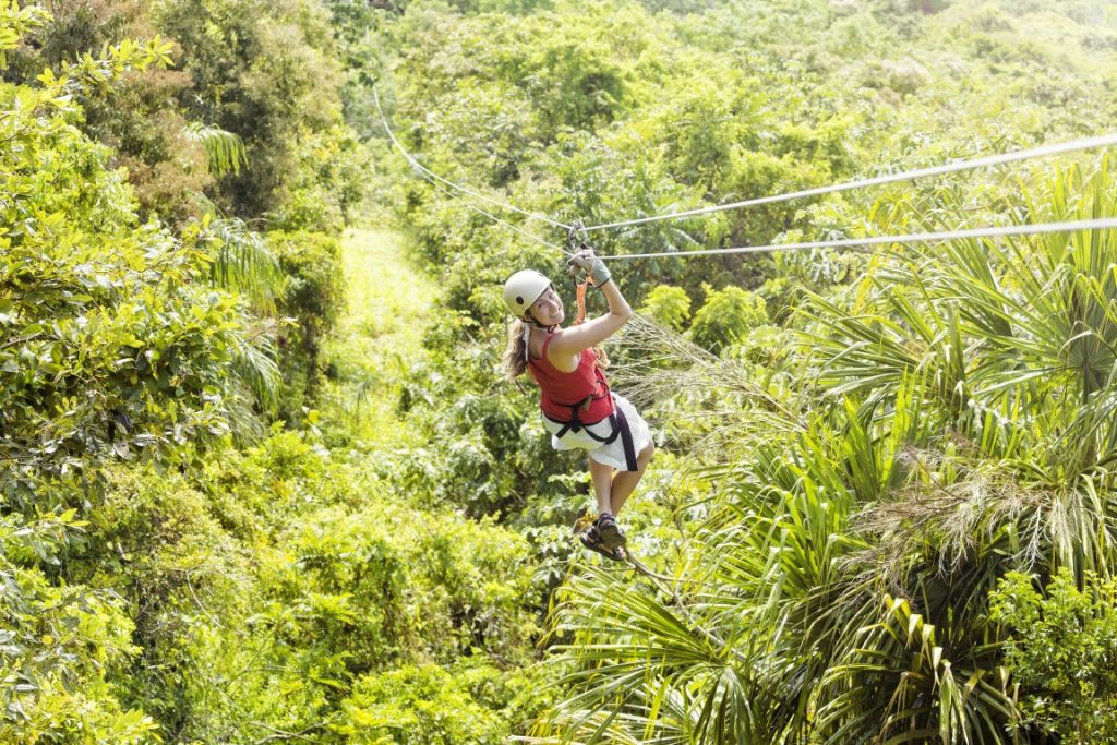 Woman ziplining in the jungle. This image was inserted in a list of the best Playa del Carmen zipline tours.