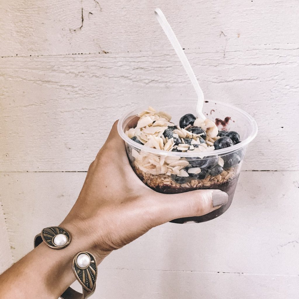 Image of a hand holding an acai bowl at Happy Bowls, one of the best restaurants in Montauk.
