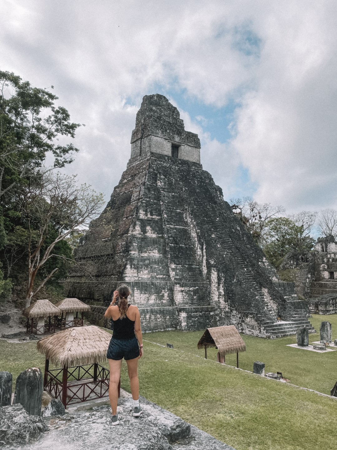 Image of a woman standing in front of the most famous pyramid in Tikal, Guatemala, inserted in a post about the best Tikal tours.