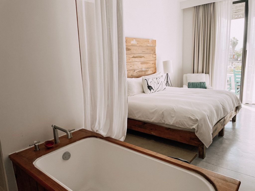 Image of a hot tub and a double bed in the background in Hotel El Ganzo, inserted in a post about ecotourism in Los Cabos