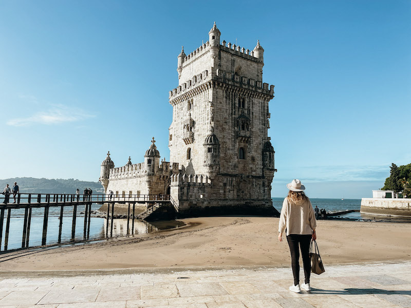 A woman looking at the Belem Tower, a must in any 3 days in Lisbon itinerary 