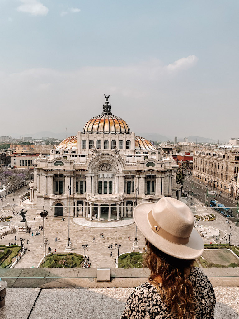 Image of a woman looking at the Palacio de Bellas Artes in Mexico City, one of the best cities in Mexico.
