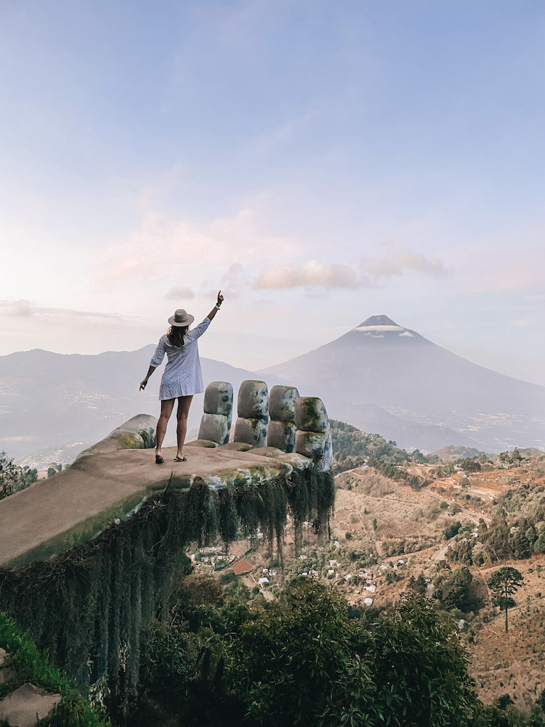 Image of a girl standing in front of a volcano at sunrise inserted in a Guatemala itinerary post.