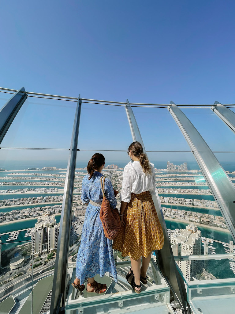 Two women standing in front of the glass at The View at the Plam, Dubai.
