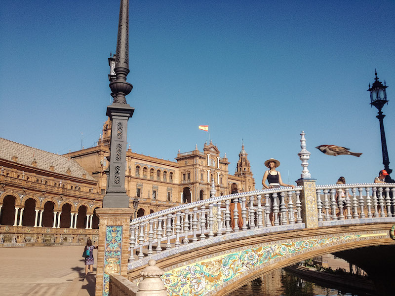 Image of a woman smiling on a beautiful bridge in Plaza de España