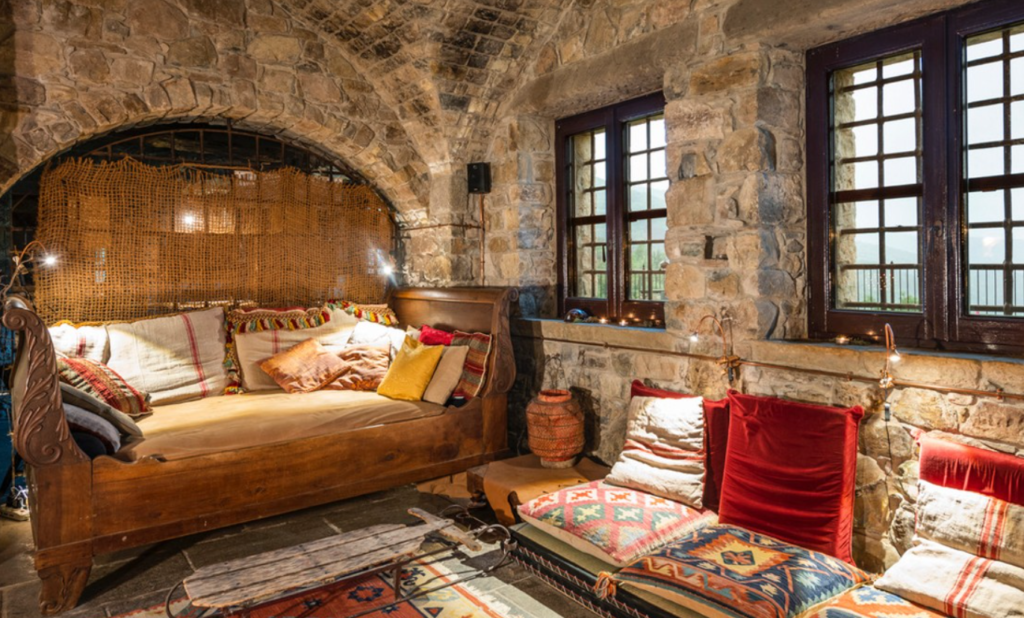 A living room corner with stone walls and cozy sitting areas in Eremito, one of the prettiest eco hotels in Italy