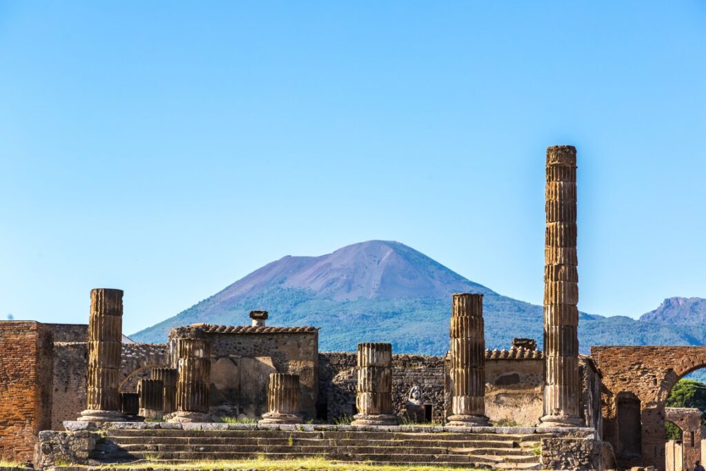 Image of ancient ruins in the archaeological site of Pompeii with Mt. Vesuvius in the background