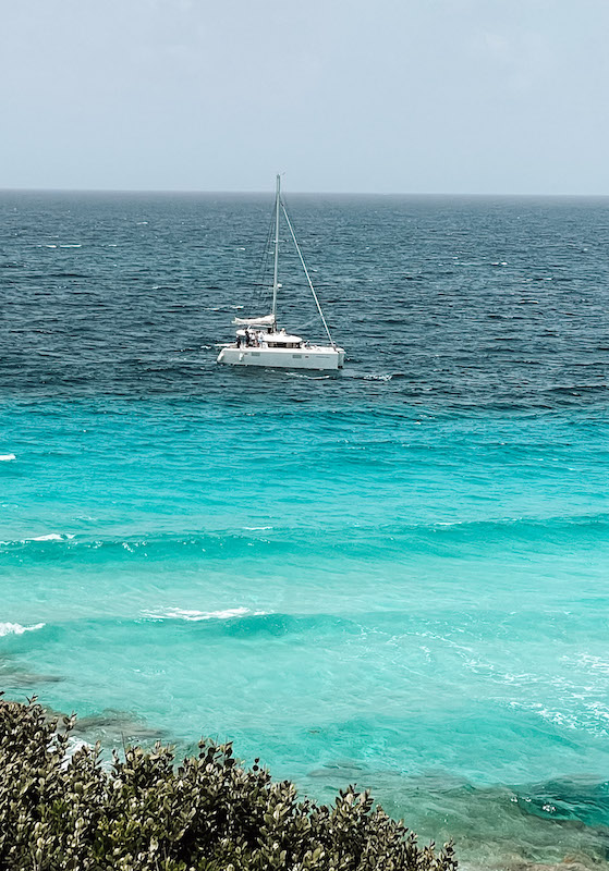 a catamaran sailing in turquoise waters, inserted in a post about Isla Mujeres catamaran tours