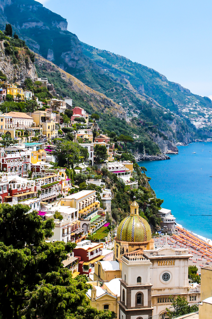 Church of Santa Maria Assunta with the town of Positano in the back, and the blue waters of the Mediterranean Sea to the left. 