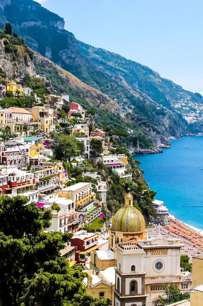 Church of Santa Maria Assunta with the town of Positano in the back, and the blue waters of the Mediterranean Sea to the left.