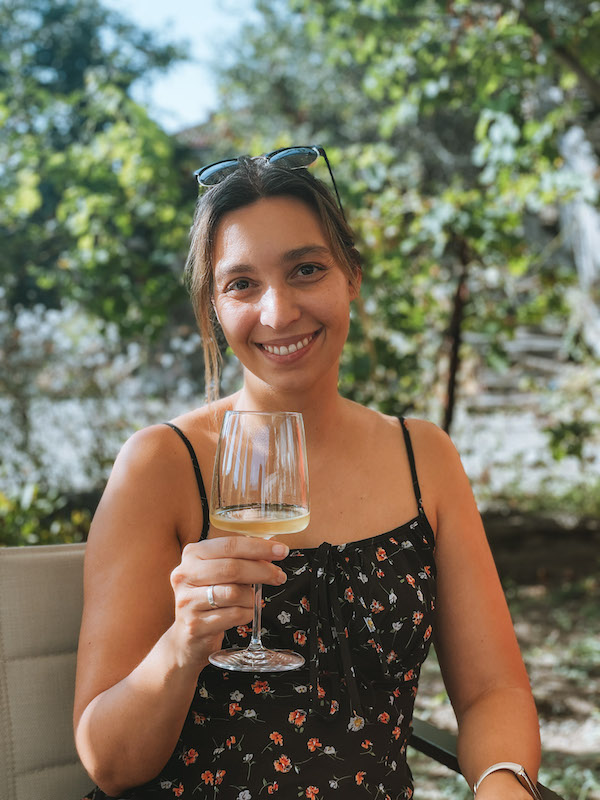 Image of a woman smiling and holding a wine glass 