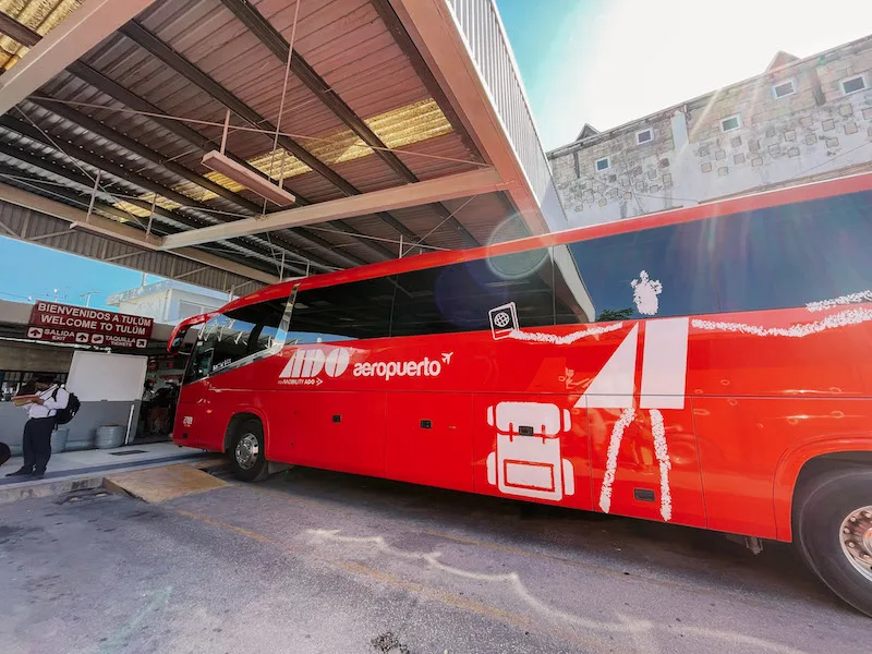 Red ADO bus from Cancun Airport to Tulum parked at Tulum bus station.