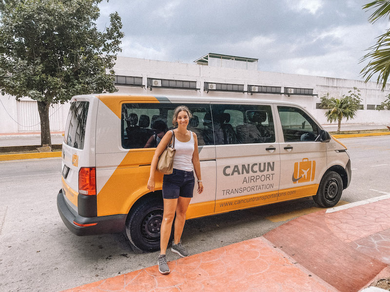 Woman standing in front of a Cancun Airport Transportation van 
