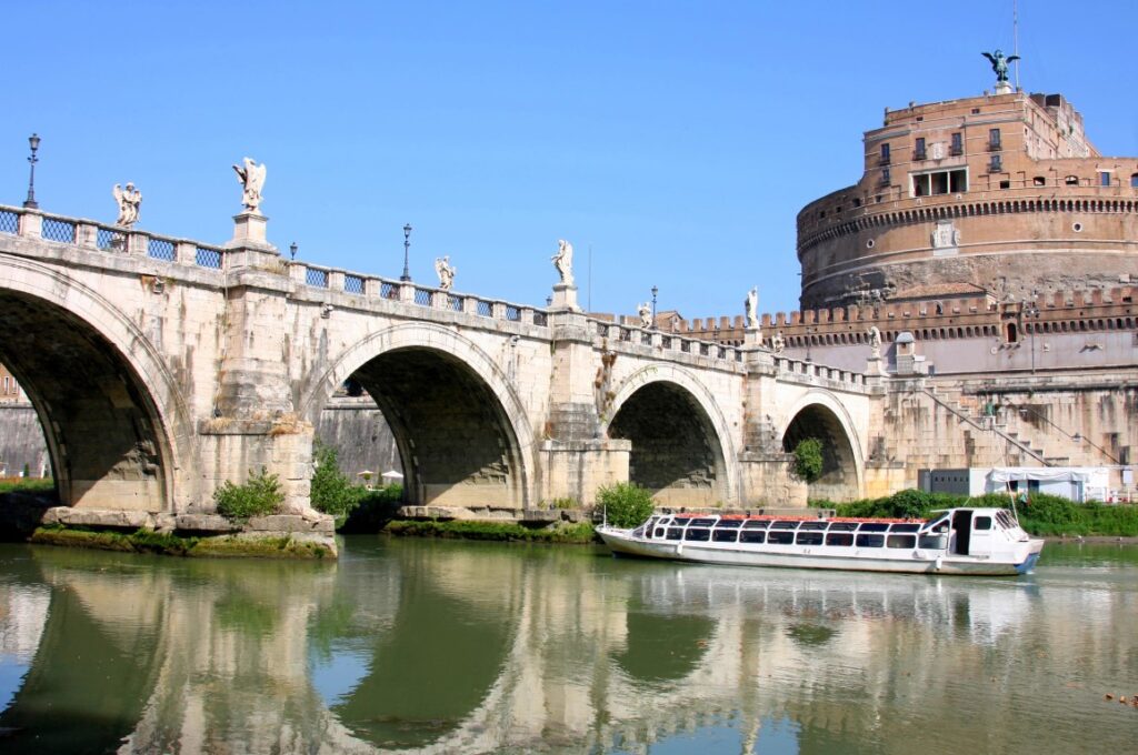 A boat gliding along the river, passing by Castel Sant'Angelo in Rome