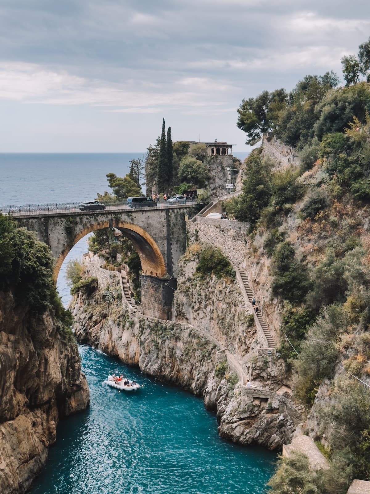 Drone photo of a boat passing under the bridge in Fiordo di Furore.