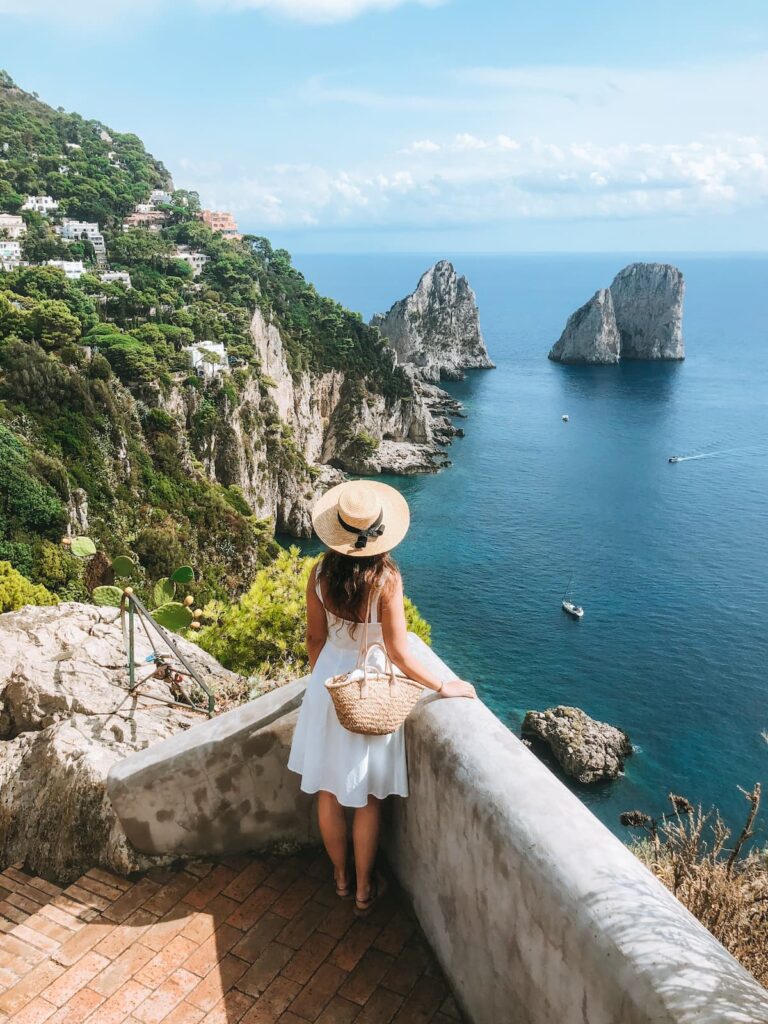 Woman looking at the Faraglioni rocks from a scenic viewpoint in Capri