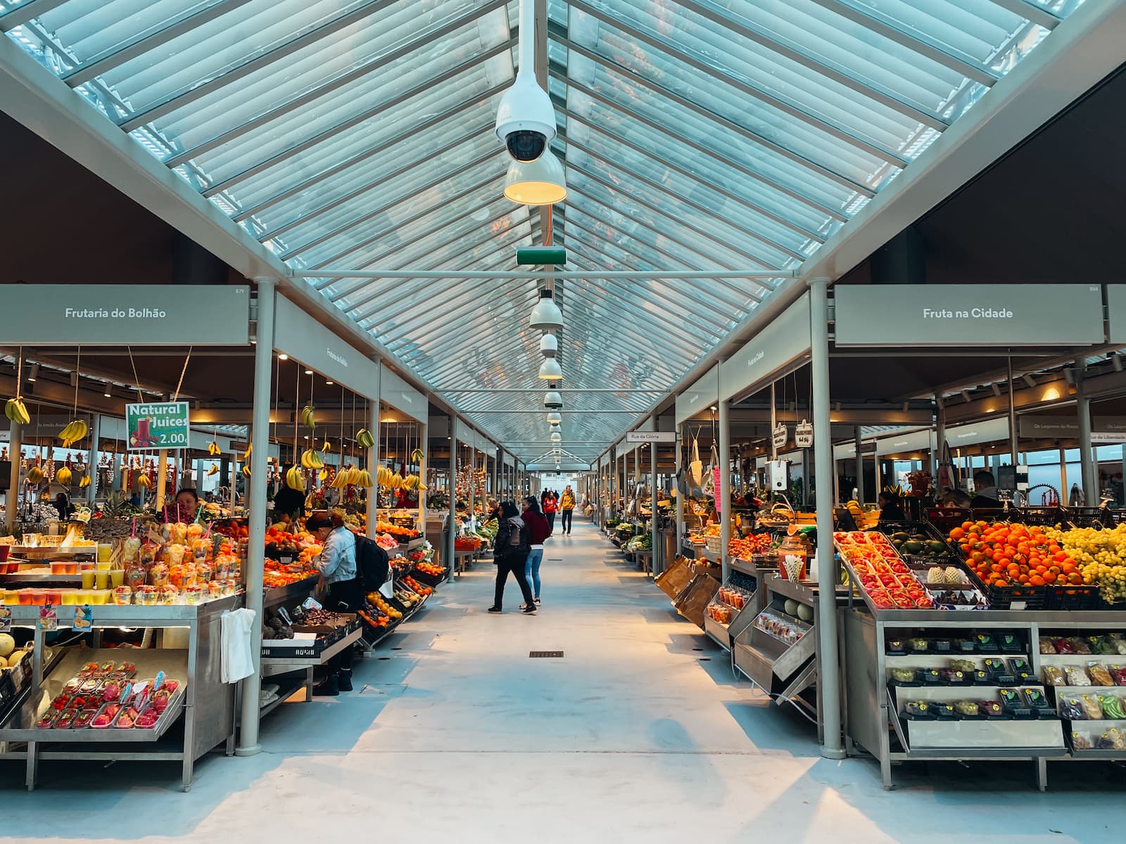 Indoor market scene at Mercado do Bolhão with fruit and vegetable stalls on both sides