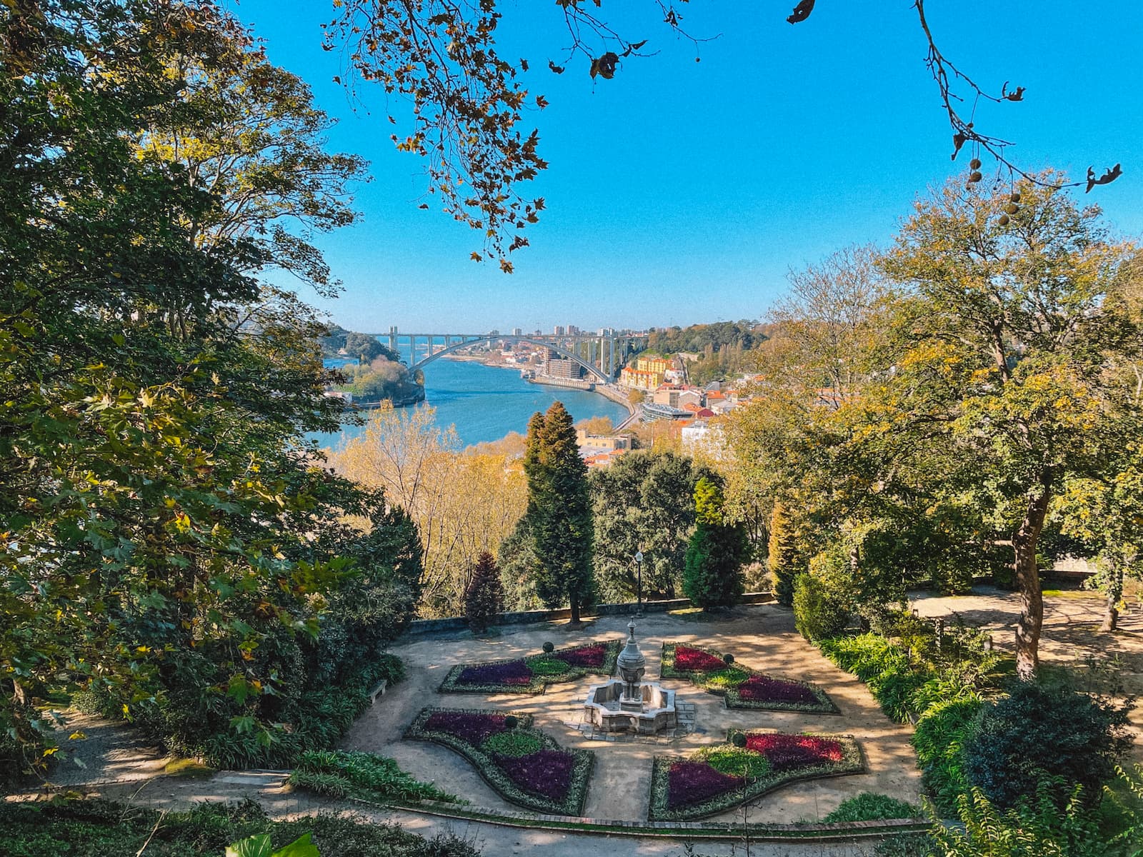 View of landscaped gardens and fountain at Jardins do Palácio de Cristal with the Douro River in the background