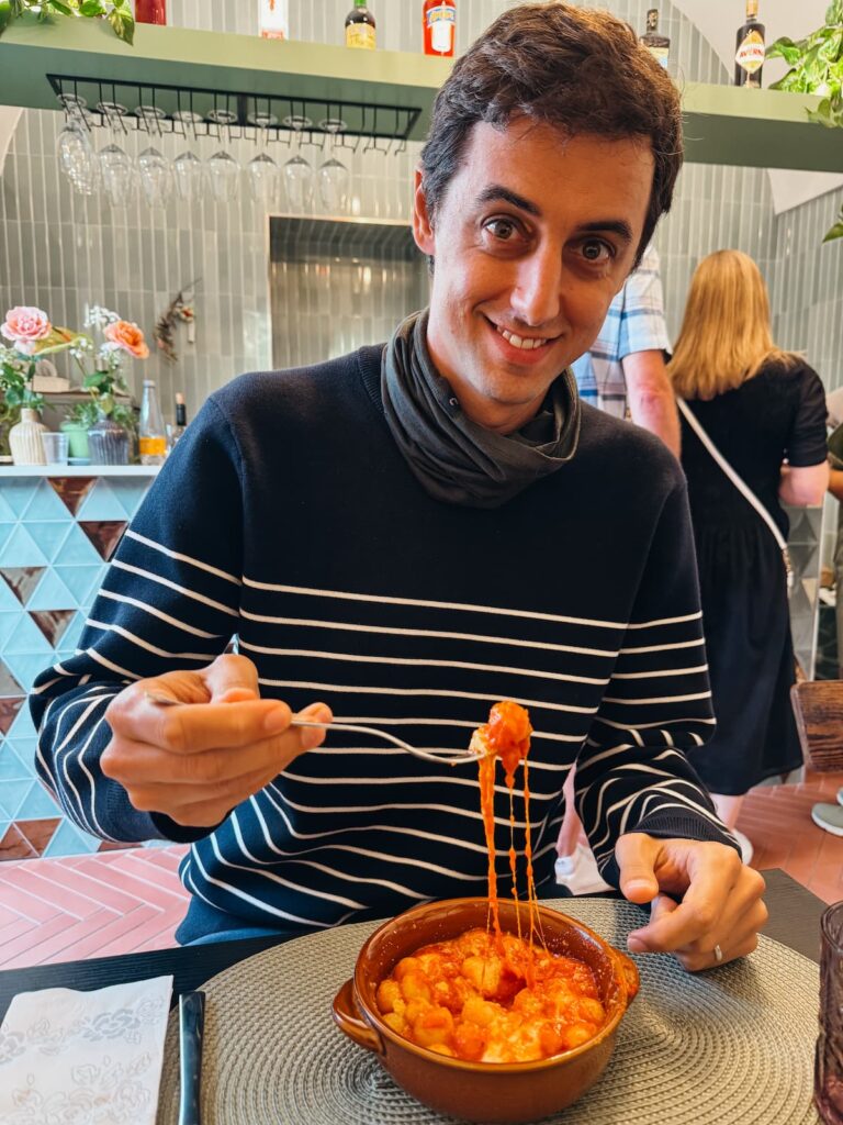 Man eating gnocchi alla Sorrentina with melted cheese in Sorrento.