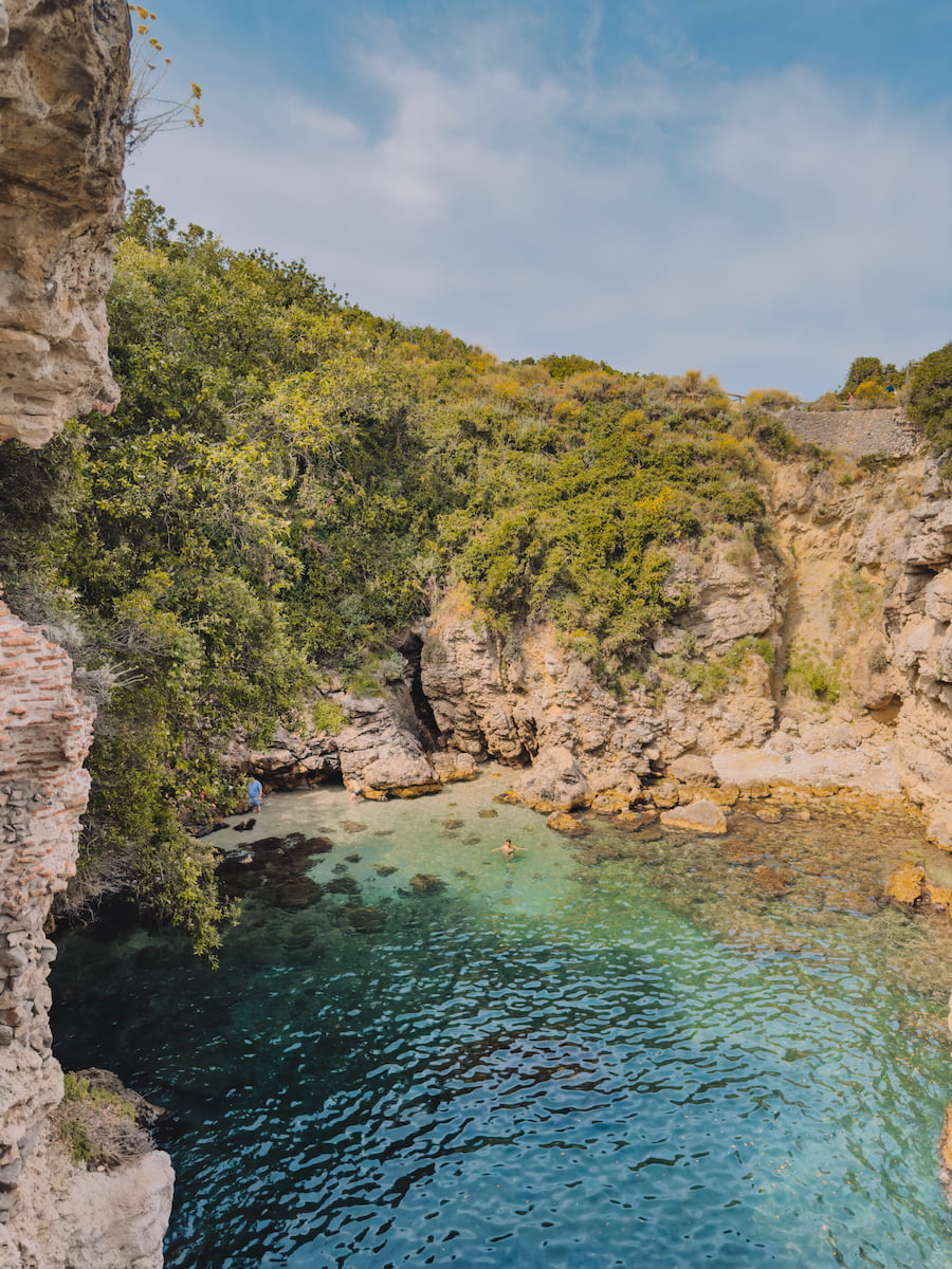 Clear water surrounded by rocky cliffs at Bagni Regina Giovanna in Sorrento.