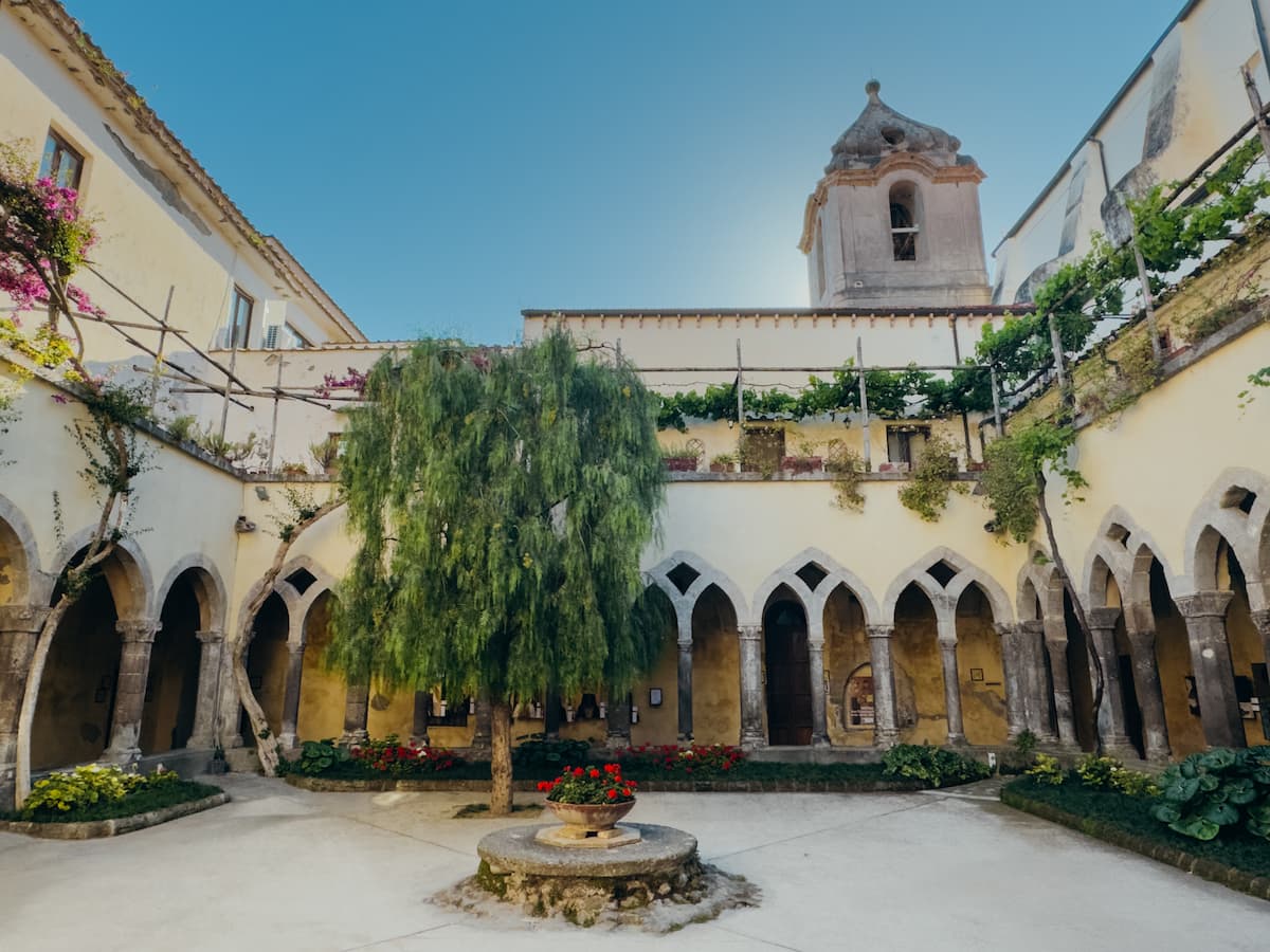 Stone arches and a leafy courtyard at the Cloister of San Francesco in Sorrento.