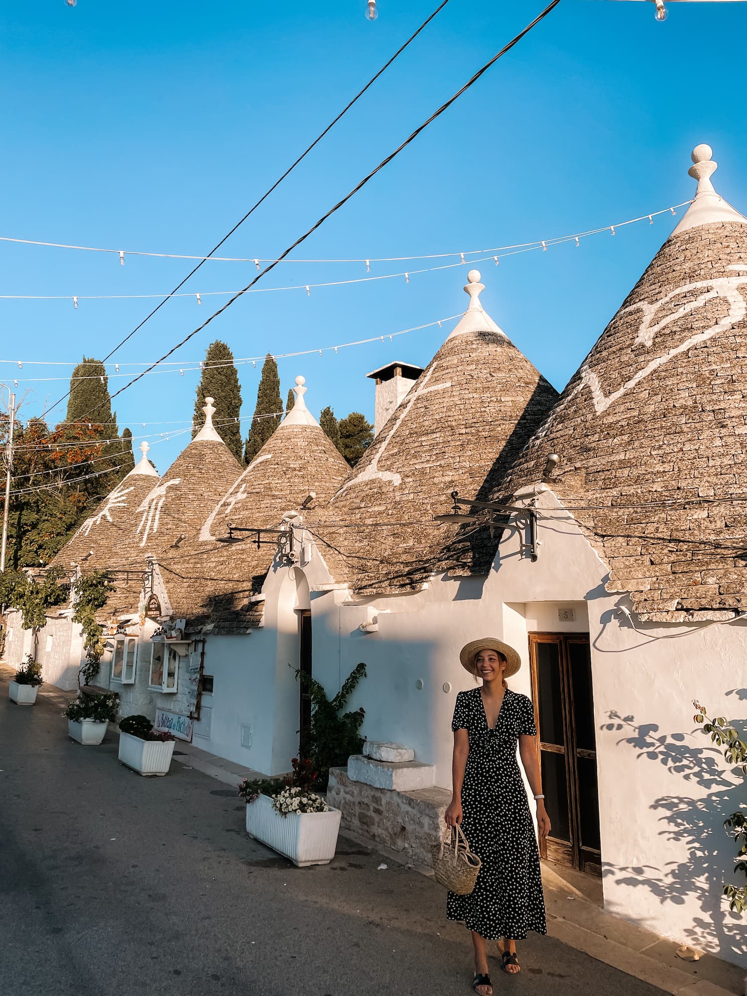 Stef standing beside traditional trulli houses in Alberobello, Italy.