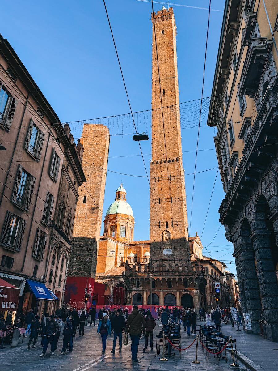 Asinelli and Garisenda towers rising above a busy street in Bologna.
