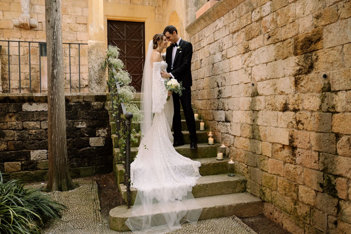 Stef and Fran on stone steps at their castle wedding in Spain.